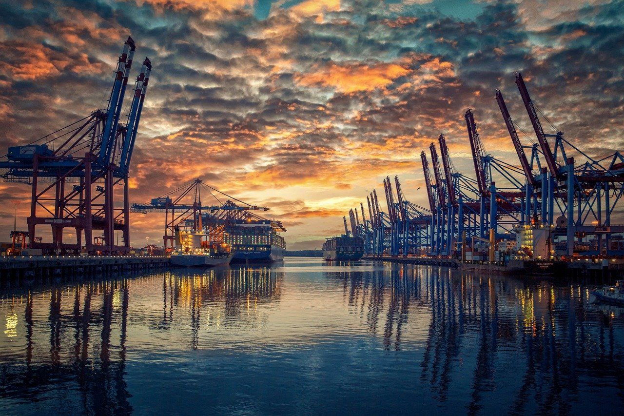 Container port and cargo cranes at sunset